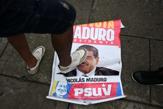 Cartaz da campanha de Nicolás Maduro é pisoteado durante protesto, no popular bairro de Petare 