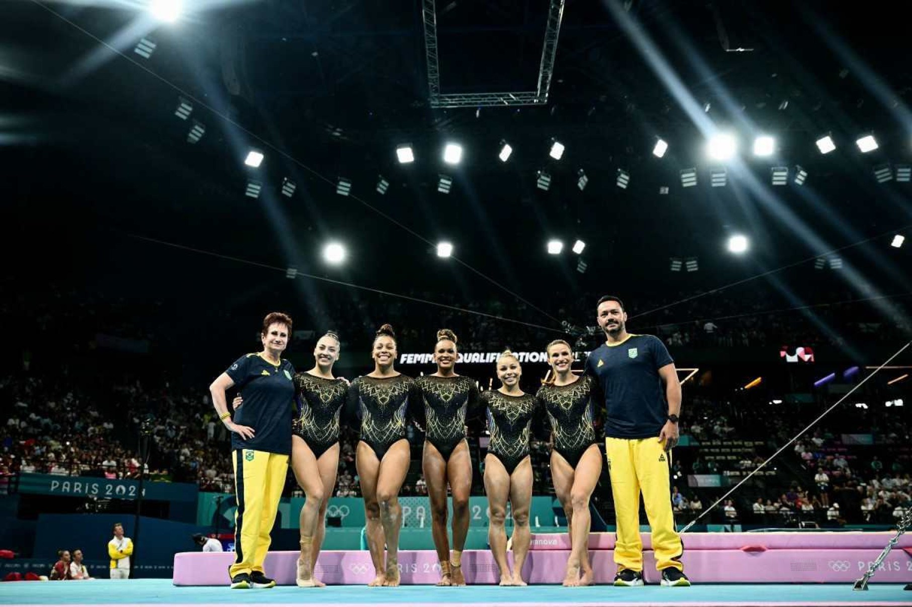  Brazils Julia Soares (2ndL), Brazils Lorrane Oliveira (3rdL), Brazils Rebeca Andrade (C), Brazils Flavia Saraiva (3rdR) and Brazils Jade Barbosa (2ndR) pose with their coaches at the end of the artistic gymnastics womens qualification during the Paris 2024 Olympic Games at the Bercy Arena in Paris, on July 28, 2024. (Photo by Loic VENANCE / AFP)       