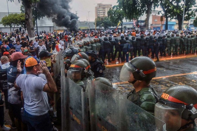 Demonstrators confront riot police during a protest against Venezuelan President Nicolas Maduro's government in Puerto La Cruz, Anzoategui state, Venezuela on July 29, 2024, a day after the Venezuelan presidential election. Venezuela braced for new demonstrations July 30, after four people died and dozens were injured when the authorities broke up protests against President Nicolas Maduro's claim of victory in the country's hotly disputed weekend election. (Photo by Carlos Landaeta / AFP)
       -  (crédito:  AFP)