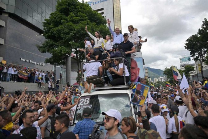 Liderados por Maria Corina Machado e Gonzalez Urrutia (no carro, com os braços levantados) multidão pede mudança de governo -  (crédito:  AFP)