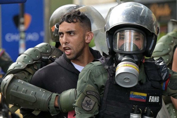  Members of the Bolivarian National Guard (GNB) riot squad arrest opponents of Venezuelan President Nicolas Maduro taking part in a demonstration, at Chacao neighbourhood in Caracas on July 30, 2024. Venezuela braced for new demonstrations after four people died and dozens were injured when the authorities broke up protests against President Nicolas Maduro's claim of victory in the country's hotly disputed weekend election. (Photo by Yuri CORTEZ / AFP)
       -  (crédito:  AFP)