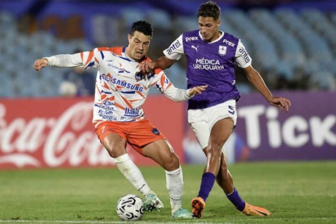  Puerto Cabello's forward Miku (L) and Defensor Sporting's midfielder Facundo Bernal fight for the ball during the Copa Libertadores' first round second leg football match between Defensor Sporting and Puerto Cabello at the Centenario stadium in Montevideo on February 13, 2024. (Photo by DANTE FERNANDEZ / AFP) (Photo by DANTE FERNANDEZ/AFP via Getty Images)
     -  (crédito:  AFP via Getty Images)