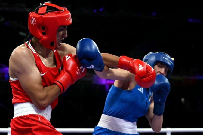 A presença da argelina Imane Khelif (de vermelho) no torneio olímpico de boxe feminino gerou críticas, inclusive de algumas lutadoras -  (crédito: MOHD RASFAN / AFP)