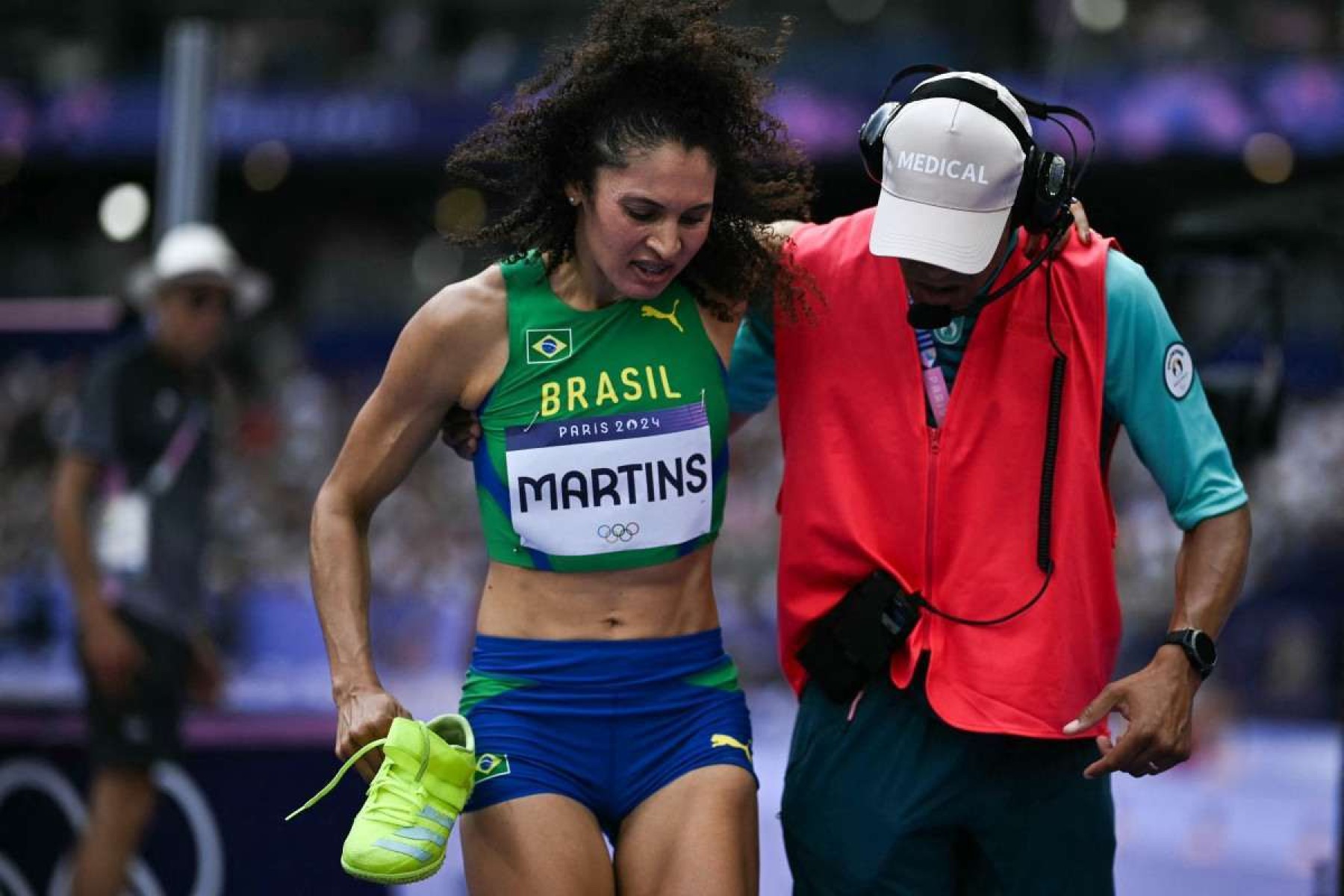  Brazils Valdileia Martins receives medical attention as she competes in the womens high jump qualification of the athletics event at the Paris 2024 Olympic Games at Stade de France in Saint-Denis, north of Paris, on August 2, 2024. (Photo by Ben STANSALL / AFP)       