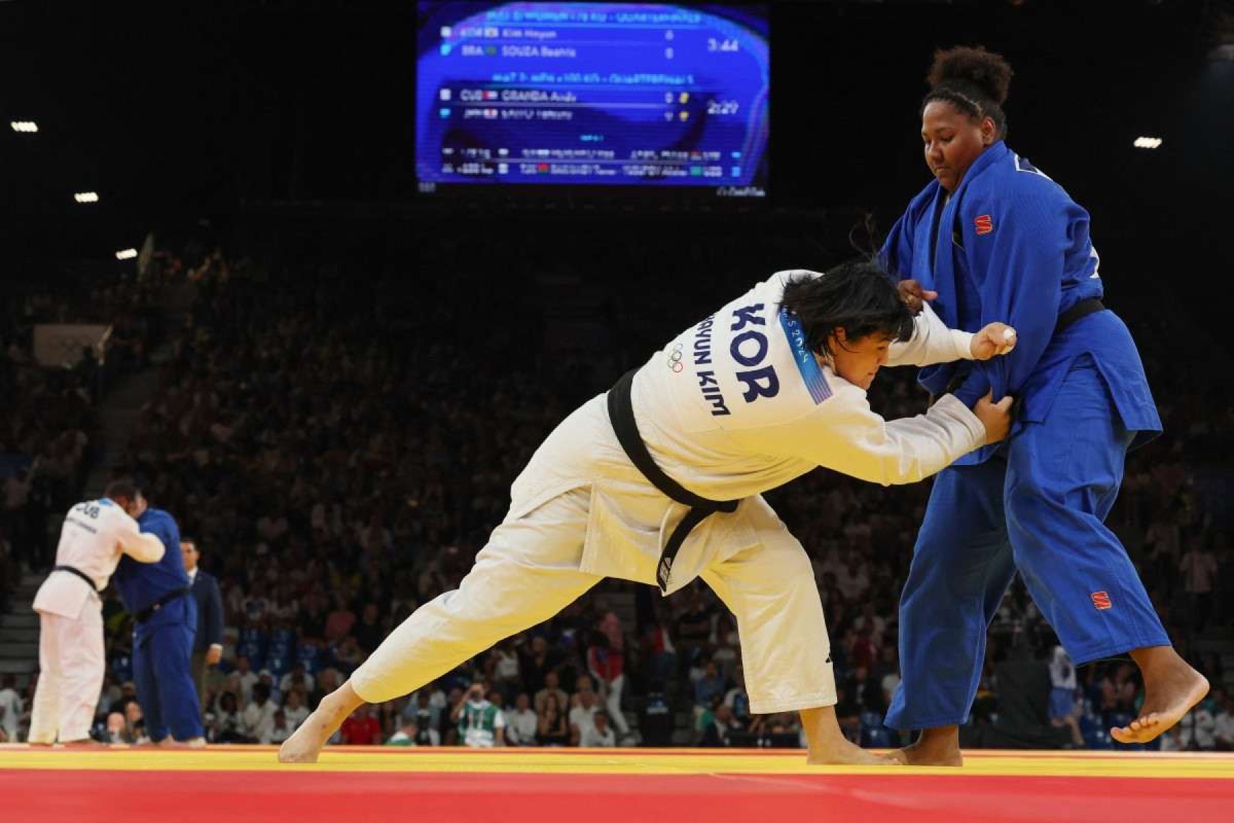  South Koreas Kim Hay-un and Brazils Beatriz Souza (Blue) compete in the judo womens +78kg quarter-final bout of the Paris 2024 Olympic Games at the Champ-de-Mars Arena, in Paris on August 2, 2024. (Photo by Jack GUEZ / AFP)       