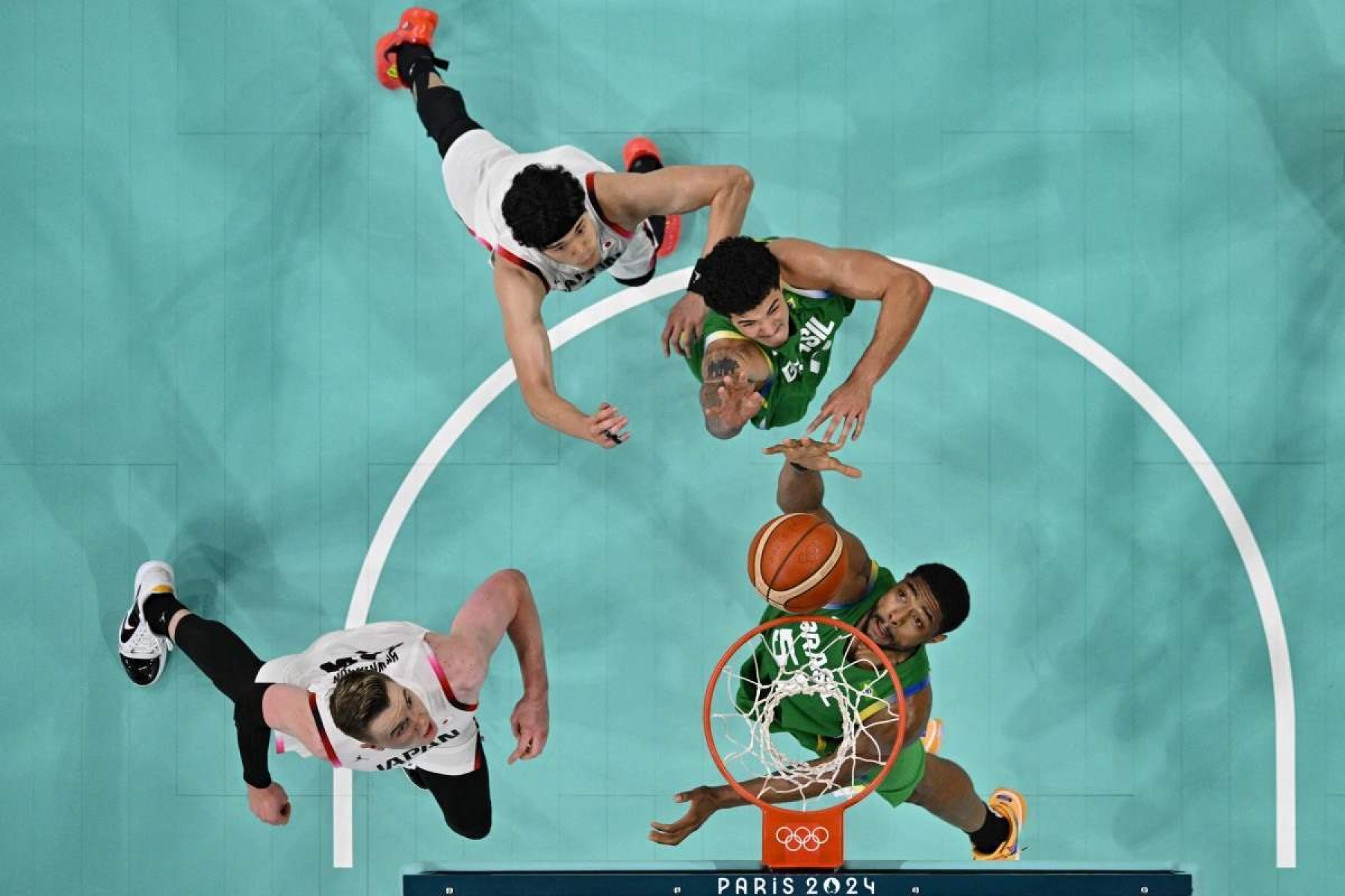 Uma visão geral mostra o 51º brasileiro Bruno Caboclo guardando a bola (parte inferior direita) enquanto o japonês nº 24 Josh Hawkinson (parte inferior esquerda) defende na partida preliminar masculina de basquete do grupo B entre Japão e Brasil durante os Jogos Olímpicos de Paris 2024 no Pierre- Estádio Mauroy em Villeneuve-dAscq, norte da França, em 2 de agosto de 2024. 