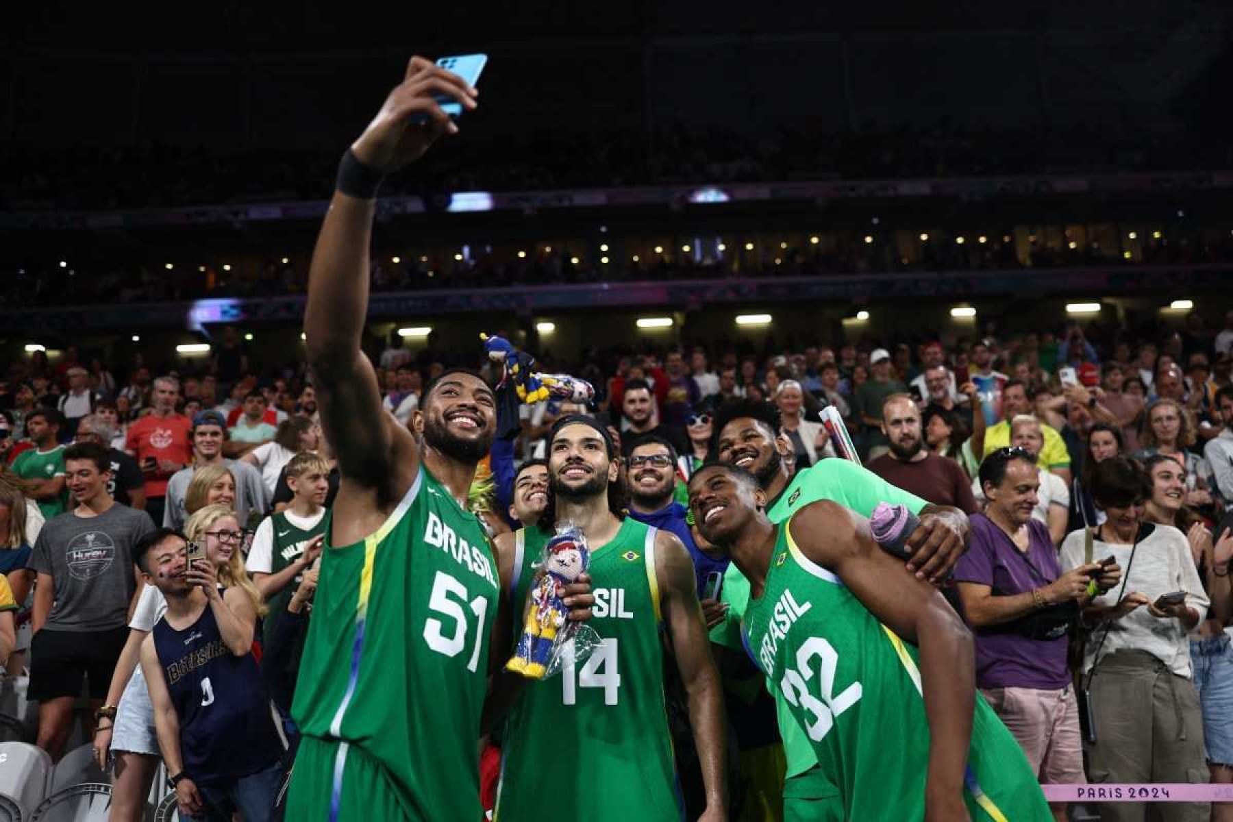 (Da esquerda para a direita) Bruno Caboclo, nº 51 do Brasil, Leo Meindl, nº 14 do Brasil, e Georginho De Paula, nº 32 do Brasil, tiram uma foto de selfie no final da partida preliminar masculina de basquete do grupo B entre Japão e Brasil durante os Jogos Olímpicos de Paris 2024, no Estádio Pierre-Mauroy em Villeneuve-dAscq, norte da França, em 2 de agosto de 2024.