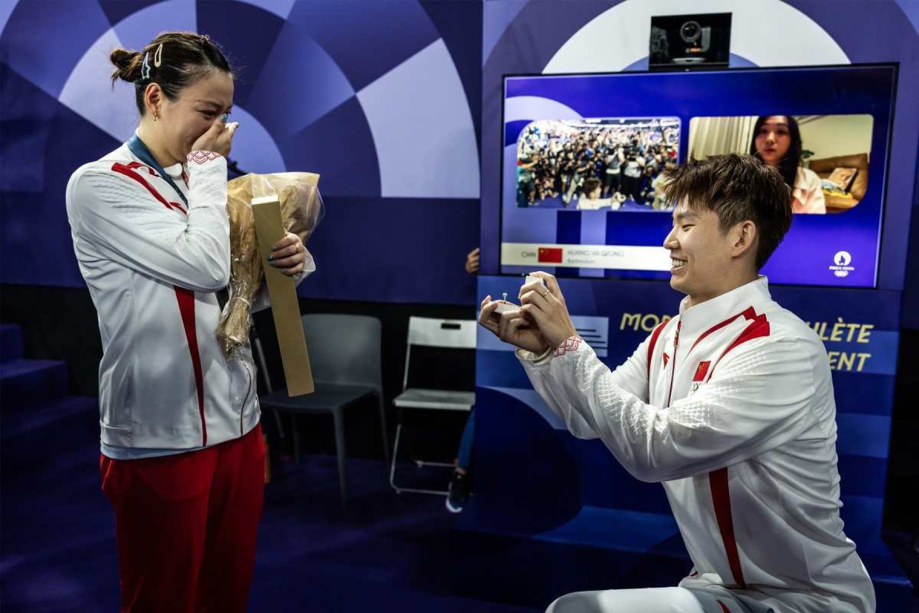 O chinês Liu Yuchen pede sua parceira e medalhista de ouro Huang Ya Qiong em casamento após deixar o pódio na cerimônia de medalha de badminton de duplas mistas durante os Jogos Olímpicos de Paris 2024 na Porte de la Chapelle Arena em Paris em 2 de agosto de 2024