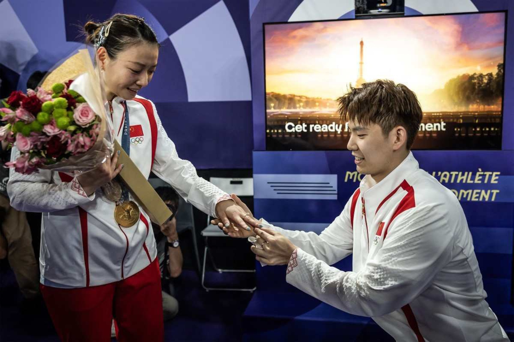 O chinês Liu Yuchen pede em casamento seu parceiro e medalhista de ouro Huang Ya Qiong depois de deixar o pódio na cerimônia de medalha de badminton de duplas mistas durante os Jogos Olímpicos de Paris 2024, na Arena Porte de la Chapelle, em Paris, em 2 de agosto de 2024. 