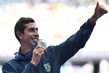 O brasileiro Caio Bonfim, medalhista de prata, comemora no pódio após competir na prova de caminhada atlética masculina de 20 km da prova de atletismo, nos Jogos Olímpicos de Paris 2024, no Stade de France, em Saint-Denis, ao norte de Paris, em 2 de agosto de 2024. -  (crédito: Andrej ISAKOVIC / AFP)