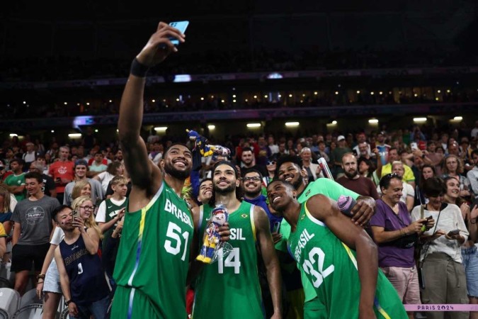 (Da esquerda para a direita) Bruno Caboclo, nº 51 do Brasil, Leo Meindl, nº 14 do Brasil, e Georginho De Paula, nº 32 do Brasil ao final da partida contra o Japão -  (crédito: Sameer AL-DOUMY / AFP)