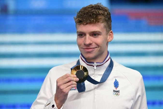  Gold medallist  France's Leon Marchand poses with his medal following the men's 200m individual medley swimming event during the Paris 2024 Olympic Games at the Paris La Defense Arena in Nanterre, west of Paris, on August 2, 2024. (Photo by Jonathan NACKSTRAND / AFP)      -  (crédito: Jonathan NACKSTRAND / AFP      )