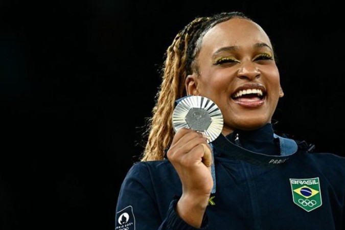 Rebeca (esquerda), Simone Biles (meio) e Sunisa Lee (direita) exibem suas medalhas no pódio da disputa do individual geral da ginástica artística -  (crédito: Foto: Paul Ellis/AFP via Getty Images)