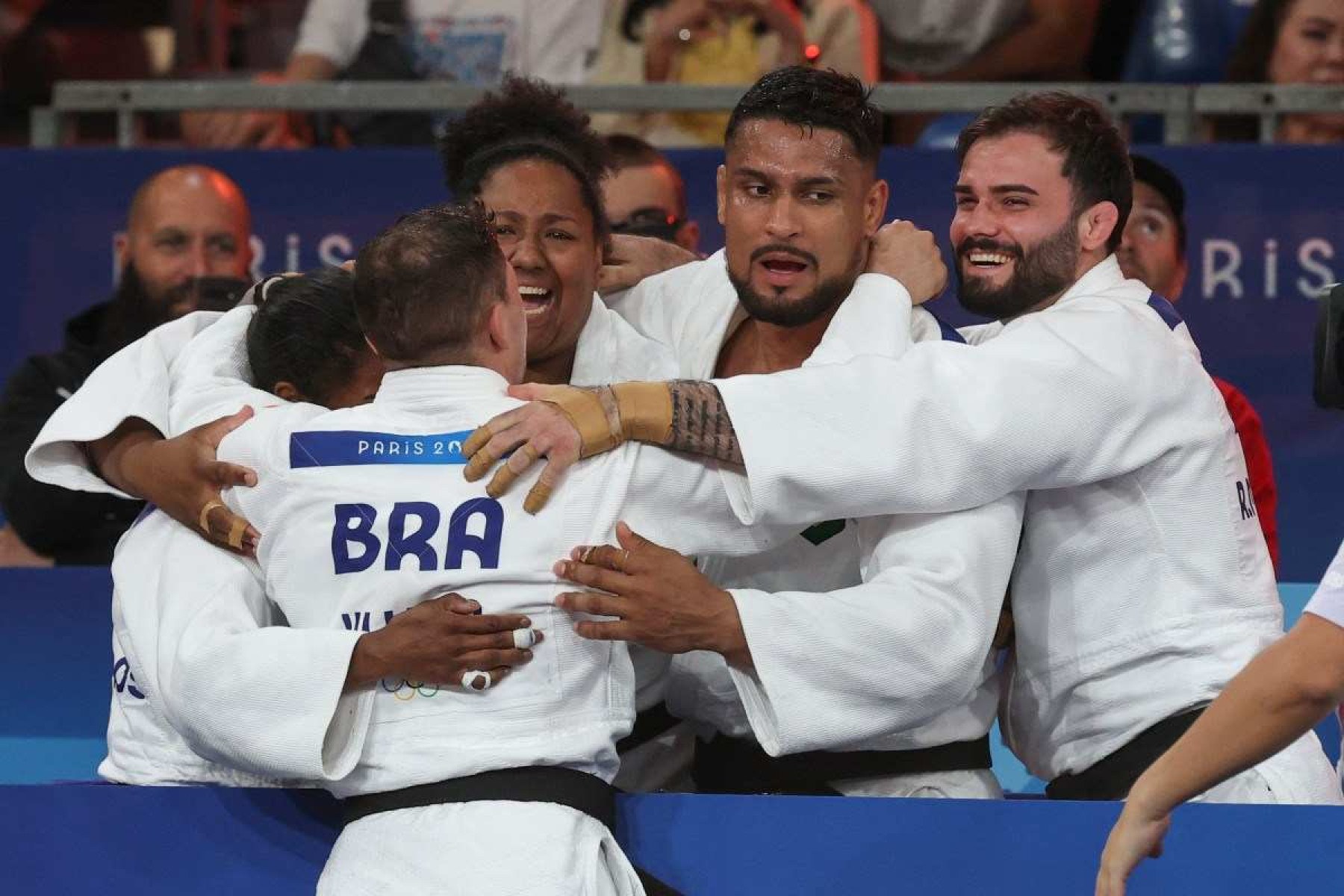 Seleção brasileira comemora após conquistar a disputa pela medalha de bronze do judô misto entre Brasil e Itália nos Jogos Olímpicos de Paris 2024, na Arena Champ-de-Mars, em Paris, no dia 3 de agosto de 2024.