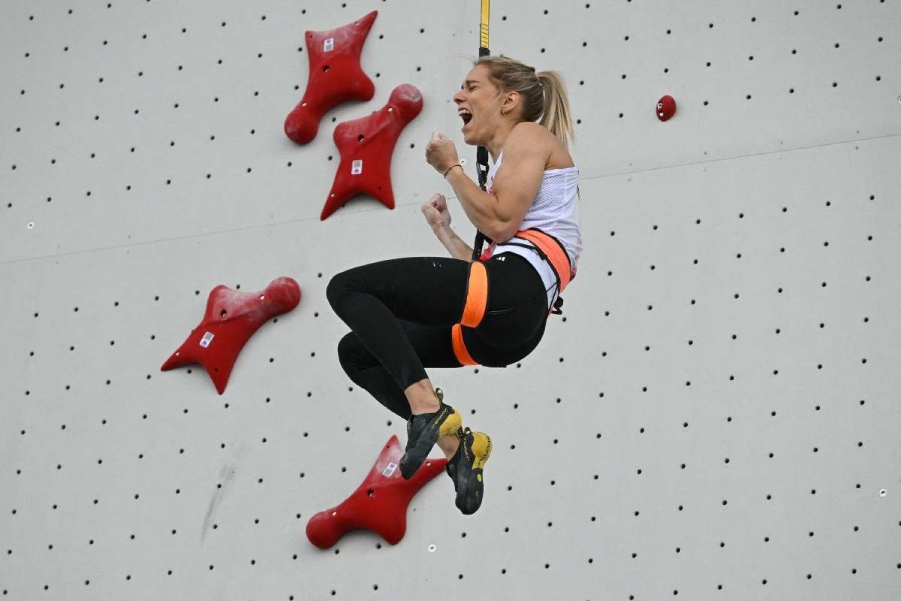  A polonesa Aleksandra Miroslaw comemora após vencer a final da velocidade de escalada esportiva feminina durante os Jogos Olímpicos de Paris 2024, no local de escalada esportiva Le Bourget, em Le Bourget, em 7 de agosto de 2024.