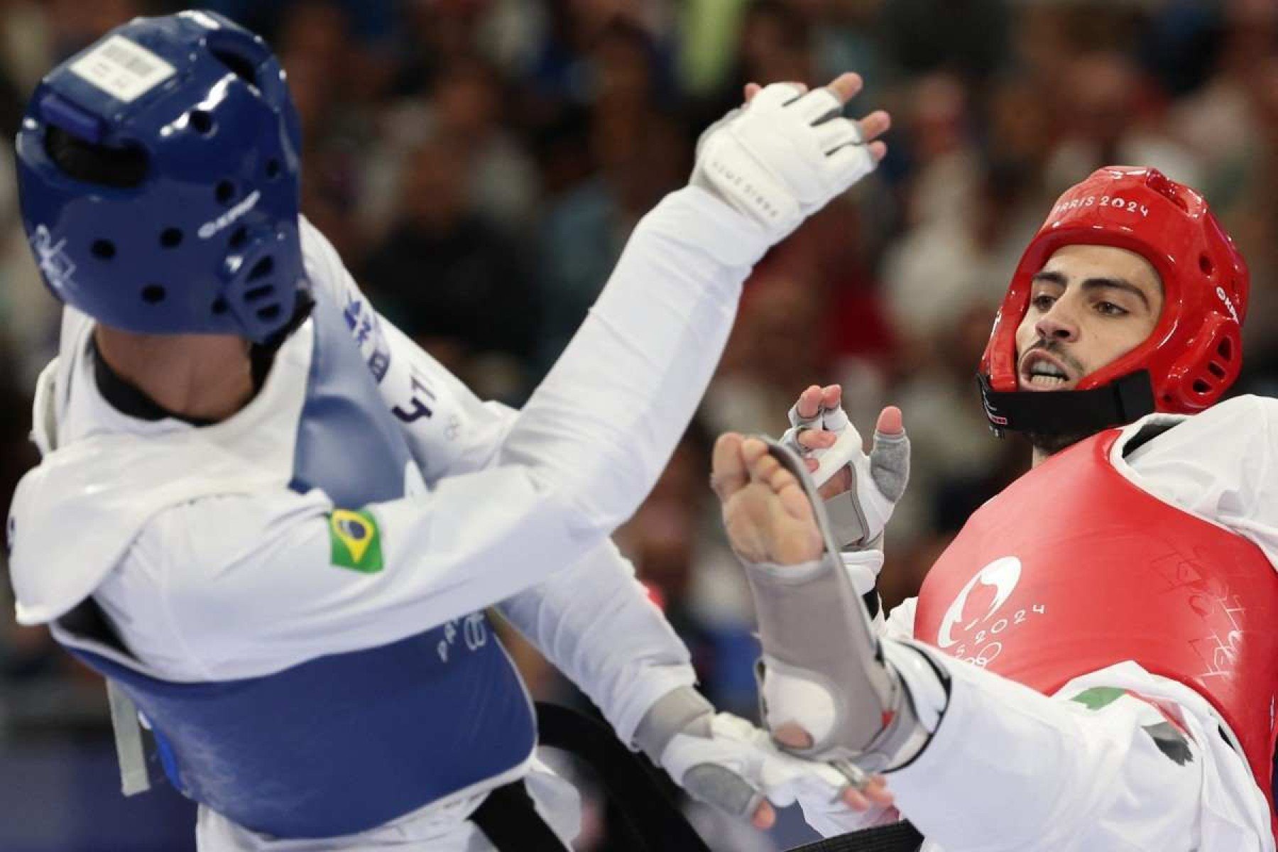 Edival Pontes (de capacete azul) lutou contra o jordaniano Zaid Kareem. Ele não conseguiu avançar às quartas de final   Brazils Edival Pontes (L) competes against Jordans Zaid Kareem in the taekwondo mens -68kg round of 16 bout of the Paris 2024 Olympic Games at the Grand Palais in Paris on August 8, 2024. (Photo by David GRAY / AFP)       