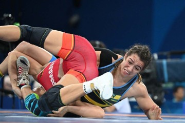 Giullia Penalber (de preto e azul) venceu a alemã Sandra Paruzewski na repescagem para disputar o bronze na luta livre feminina -  (crédito: Punit Paranjpe/AFP)