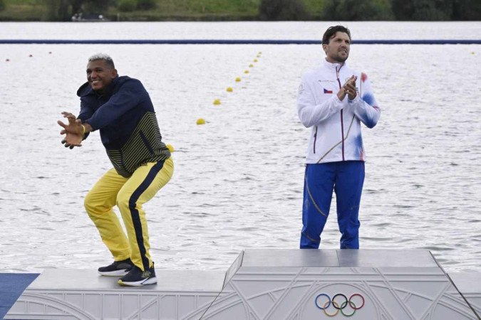 (Da esquerda para a direita) O medalhista de prata do Brasil Isaquias Guimarães Queiroz, o medalhista de ouro da República Tcheca Martin Fuksa e o medalhista de bronze da Moldávia Serghei Tarnovschi comemoram no pódio durante a cerimônia de medalhas após a final dos 1000 m de canoagem individual masculina da competição de canoagem velocidade no Estádio Náutico de Vaires-sur-Marne em Vaires-sur-Marne durante os Jogos Olímpicos de Paris 2024, em 9 de agosto de 2024.       -  (crédito: Olivier MORIN / AFP)