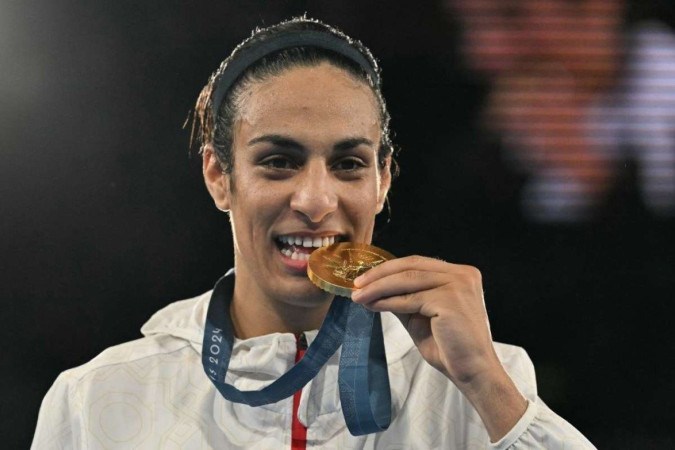 A argelina Imane Khelif, medalhista de ouro, posa no pódio durante a cerimônia de medalhas da categoria final feminina de boxe até 66kg durante os Jogos Olímpicos de Paris 2024 -  (crédito: MOHD RASFAN / AFP)