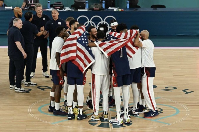 Jogadores da seleção dos EUA comemoram a vitória na partida de basquete masculino pela medalha de ouro -  (crédito: Paul ELLIS / AFP)