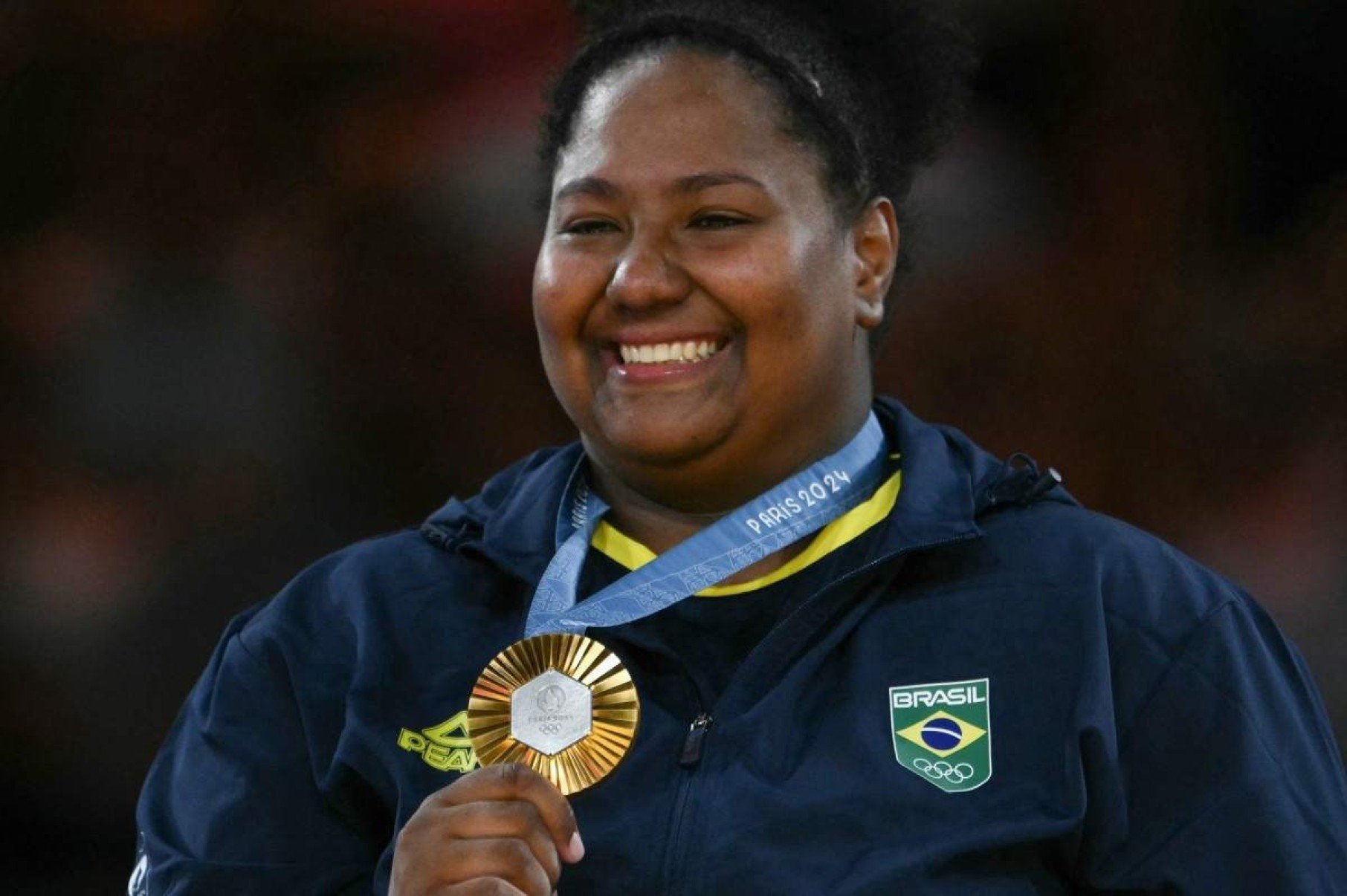  Gold medallist Brazils Beatriz Souza celebrates on the podium after the judo womens +78kg gold medal bout of the Paris 2024 Olympic Games at the Champ-de-Mars Arena, in Paris on August 2, 2024. (Photo by Luis ROBAYO / AFP)       