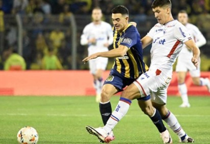 Lovera (de amarelo e azul)  leva o Rosario ao ataque, mas é marcado de perto por Cardona, do Fortaleza   -  (crédito: Foto: Marcelo Manera / AFP via Getty Images)