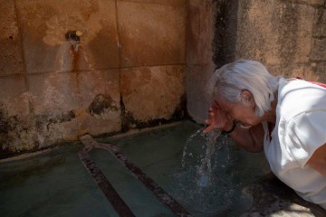  (FILES) A woman cools off in a fountain in Ronda, southern Spain as the country faces the fourth heatwave of the summer, on August 9, 2024. Spain experienced in August 2024 a 21-day heat wave in three of the largest cities in Spain - Madrid, Barcelona and Zaragoza - with severe health consequences induced. (Photo by JORGE GUERRERO / AFP)
       -  (crédito: JORGE GUERRERO / AFP)