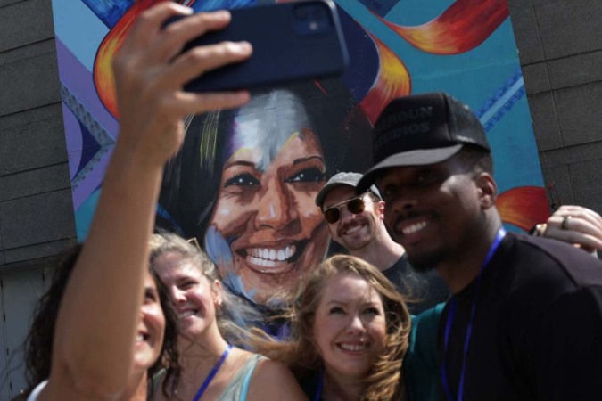 Simpatizantes de Kamala Harris fazem selfie diante de mural no United Center, local da Convenção Democrata, em Chicago -  (crédito: Alex Wong/Getty Images/AFP)