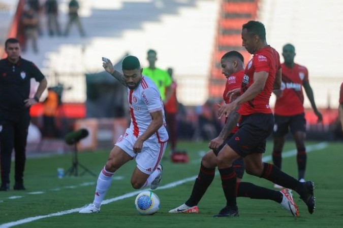 Bruno Tabata recebe marcação dupla do Atlético-GO. Apoiador do Inter luta muito. Mas vê seu time perder em Goiânia -  (crédito: Foto: Ricardo Duarte / Internacional)