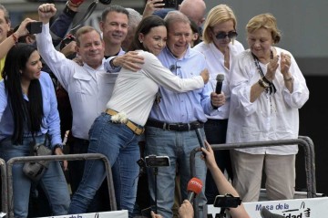 A líder antichavista Maria Corina Machado abraçada a Edmundo González durante protesto -  (crédito:  AFP)