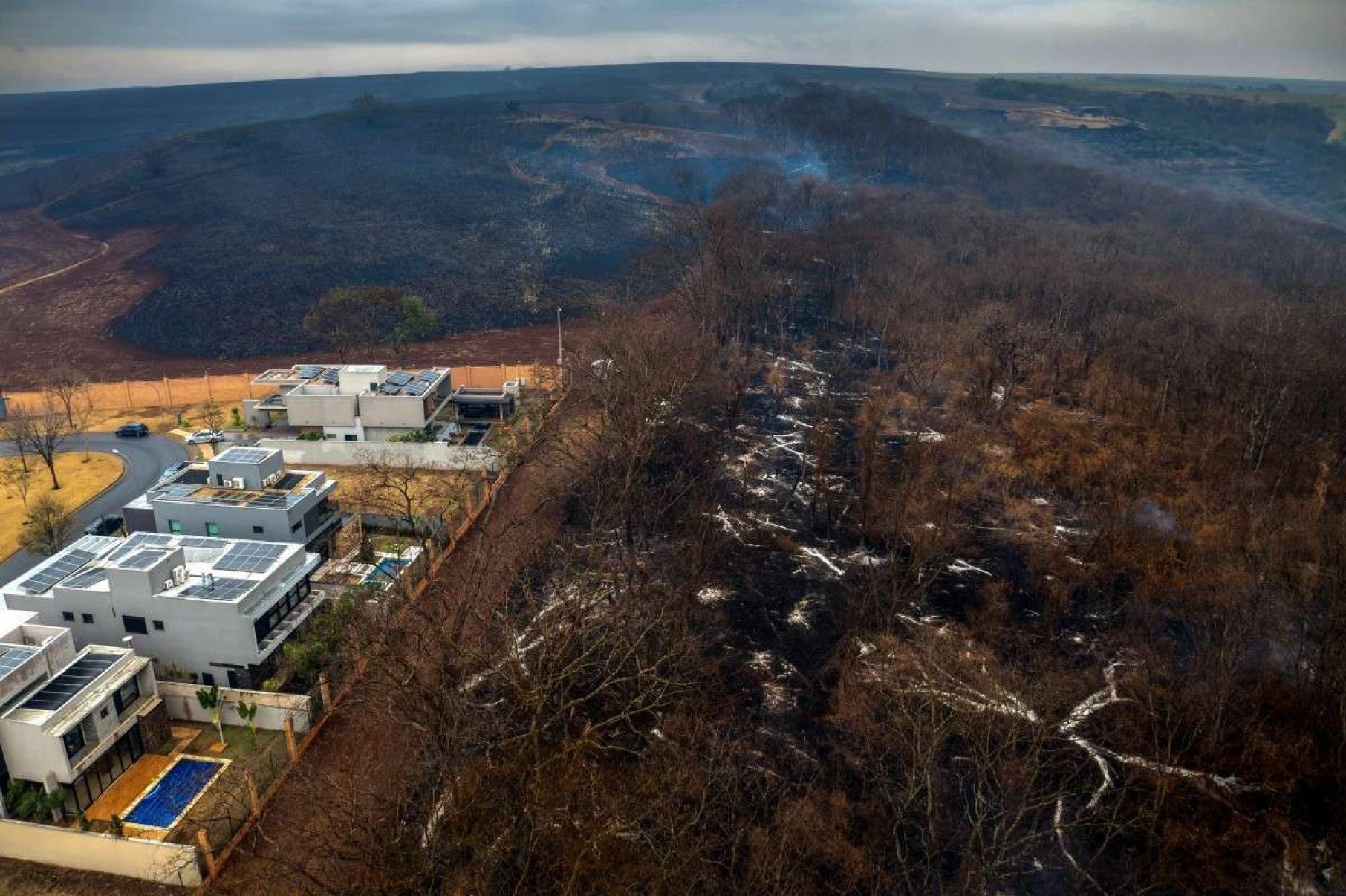 Vista aérea de vegetação em chamas próximo a um condomínio de luxo na cidade de Ribeirão Preto, estado de São Paulo, Brasil, em 25 de agosto de 2024      