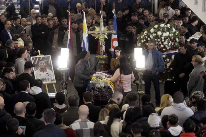  TOPSHOT - People mourn next to the coffin of late Uruguay's Nacional football player Juan Manuel Izquierdo in Montevideo on August 29, 2024. Uruguay farewell Nacional footballer Juan Izquierdo, whose body was repatriated from Brazil, where the player suffered a heart attack in the middle of a Copa Libertadores match. (Photo by Dante Fernandez / AFP) (Photo by DANTE FERNANDEZ/AFP via Getty Images)
     -  (crédito:  AFP via Getty Images)