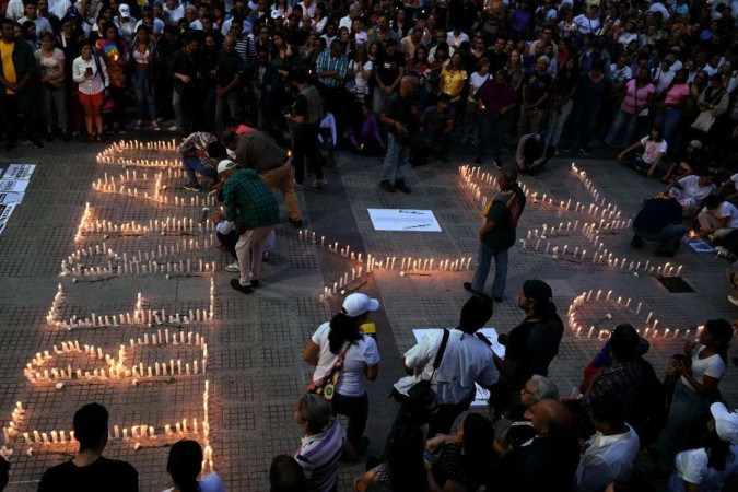 Moradores de Caracas acendem velas formando as palavras 