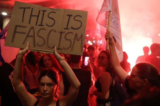 Com cartazes e faixas, as pessoas falam em 