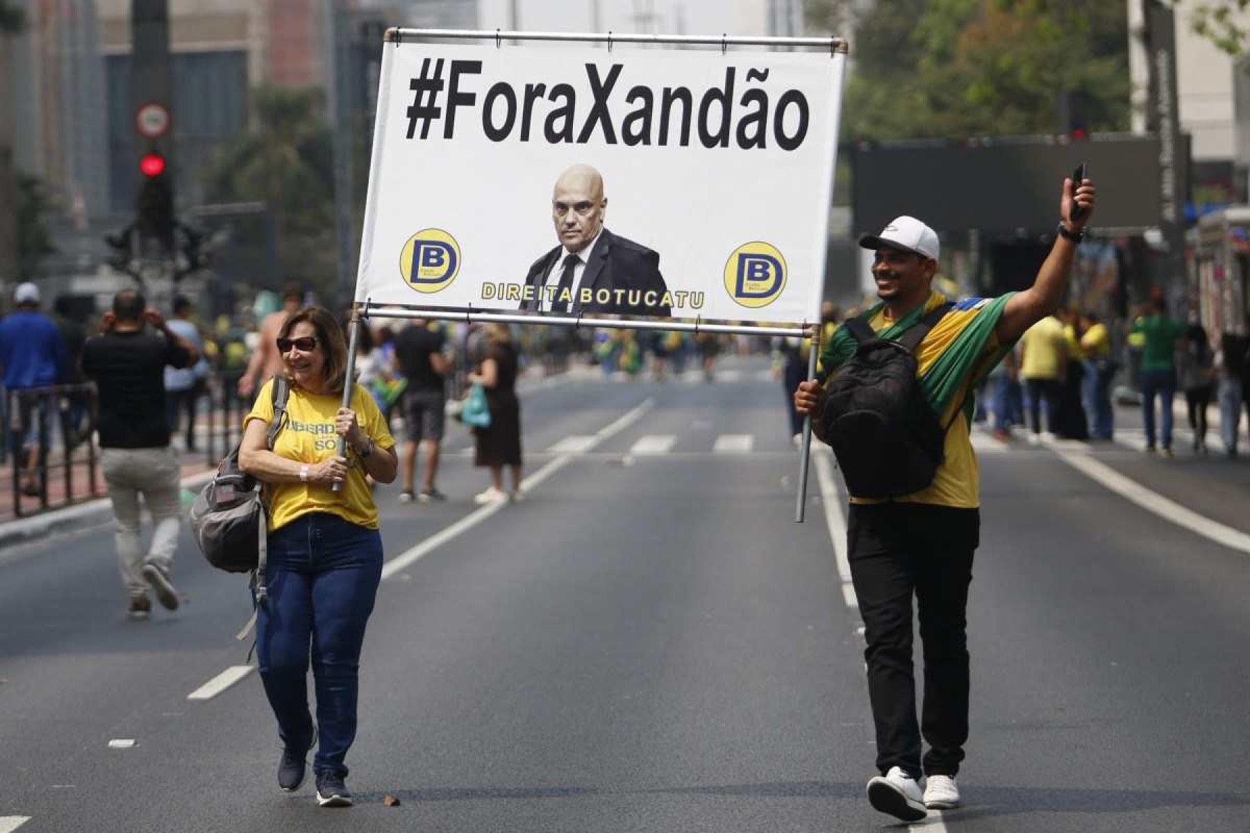     Apoiadores do ex-presidente brasileiro Jair Bolsonaro (2019-2022) seguram uma placa contra o juiz do Supremo Tribunal Federal Alexandre de Moraes, durante um comício do Dia da Independência em São Paulo, Brasil, em 7 de setembro de 2024. (Foto de Miguel SCHINCARIOL / AFP)       