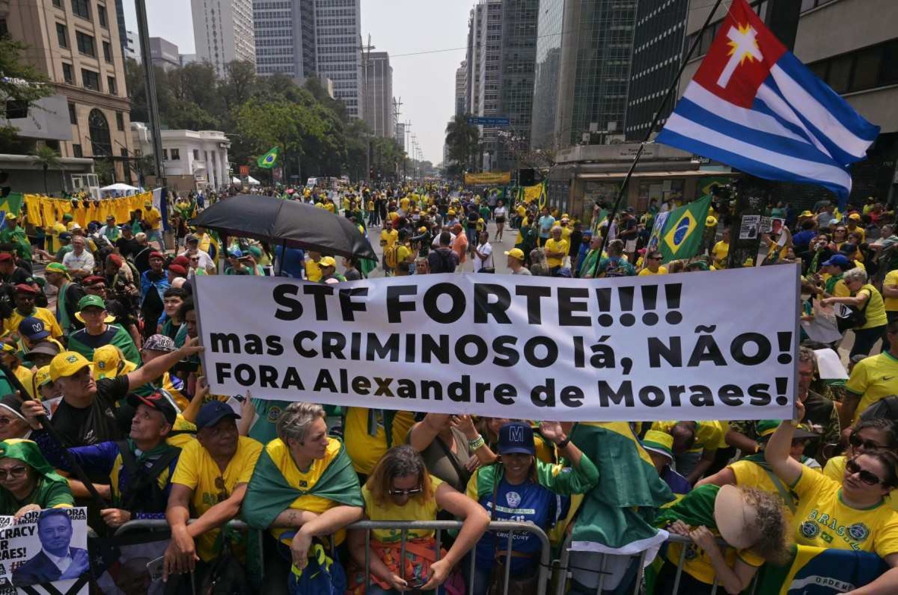     Apoiadores do ex-presidente brasileiro Jair Bolsonaro (2019-2022) seguram uma placa contra o juiz do Supremo Tribunal Federal Alexandre de Moraes, durante um comício do Dia da Independência em São Paulo, Brasil, em 7 de setembro de 2024. (Foto de NELSON ALMEIDA / AFP)       