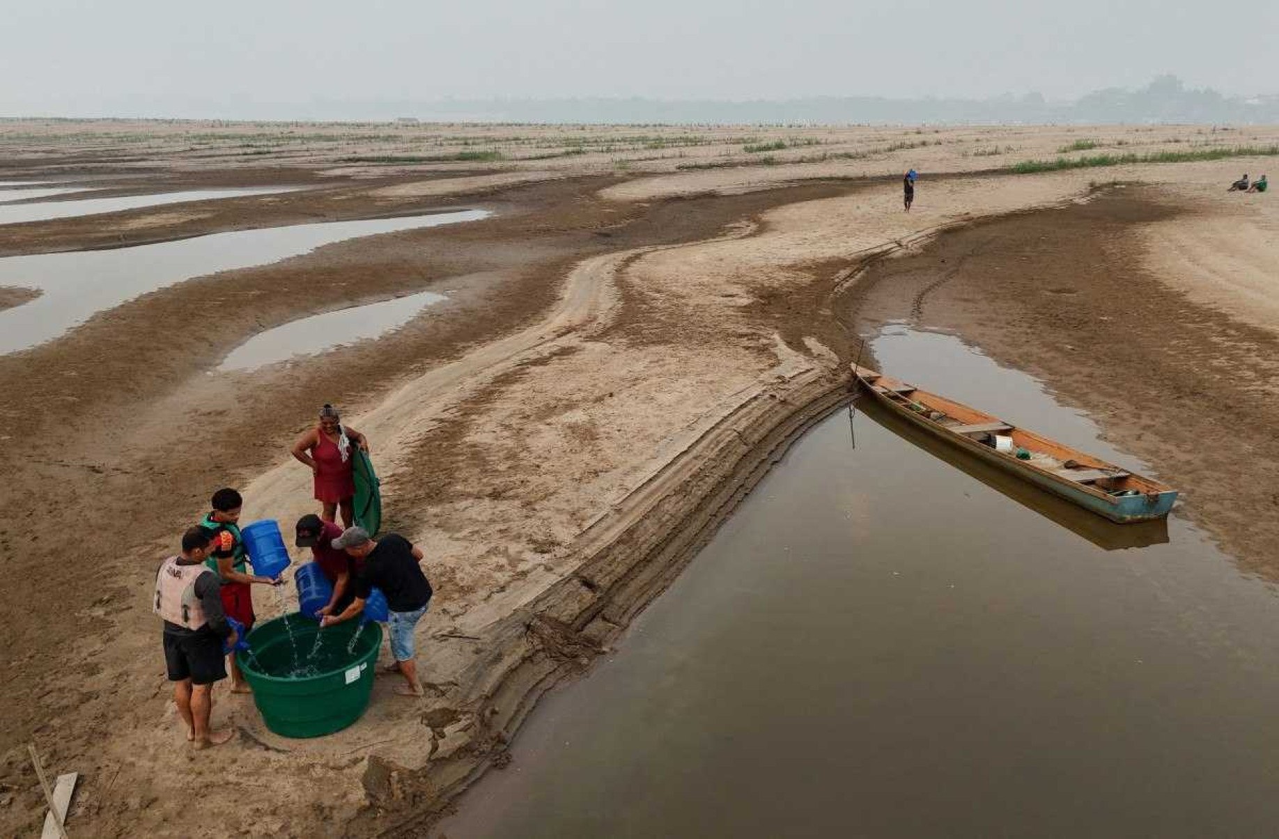 Ribeirinhos presos no leito de um rio que arde devido à seca na Amazônia