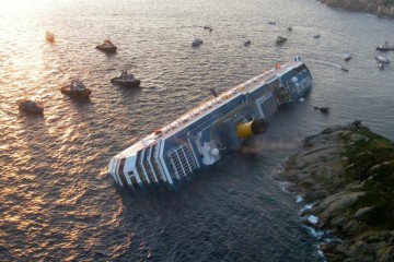 Esta foto de arquivo tirada em 14 de janeiro de 2012, uma vista aérea de apostila tirada e divulgada pela Guardia de Finanza italiana, mostra o Costa Concordia um dia depois que o navio de cruzeiro encalhou e tombou na Isola del Giglio, tarde em 13 de janeiro -  (crédito: GUARDIA DI FINANZA PRESS OFFICE / AFP)