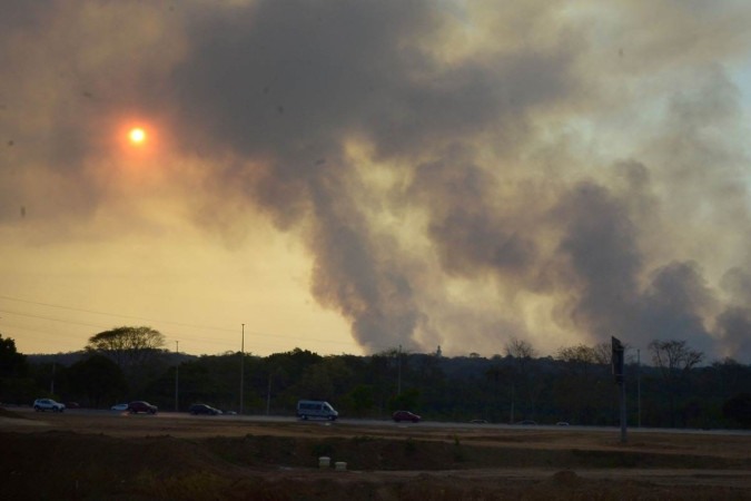 A fumaça deixou o céu acinzentado e foi vista por moradores em vários pontos da capital. ICMBio, Ibram e bombeiros atuam para conter o incêndio -  (crédito: Fotos: Marcelo Ferreira/CB/D.A Press)