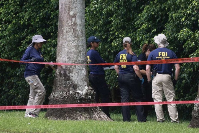 Agentes do FBI coletam evidências nos arbustos onde o potencial atirador ficou escondido por 12 horas, no clube de golfe de Trump -  (crédito: Joe Raedle/Getty Images/AFP)