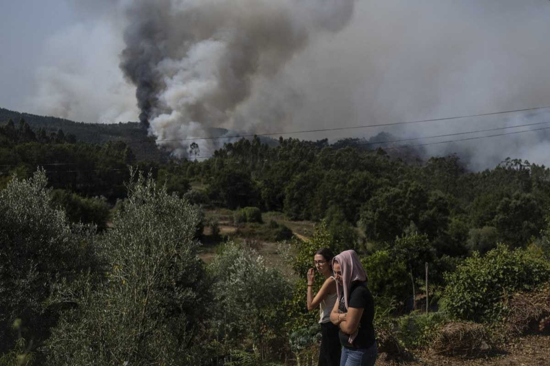 Aldeões observam coluna de fumo durante incêndio florestal em Lourizela, Águeda, Aveiro, a 18 de setembro de 2024      