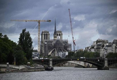  (FILES) This photograph shows a view of Notre-Dame Cathedral in reconstruction with scaffholdings and a view of the Seine River, in Paris, on July 10, 2024. Archeological digs in Notre-Dame Cathedral have led to the discovery of a tomb believed to  belong to the late poet Joachim du Bellay, for whom records show he was buried in the cathedral though the exact location was unknown. (Photo by JULIEN DE ROSA / AFP)
       -  (crédito: JULIEN DE ROSA / AFP)