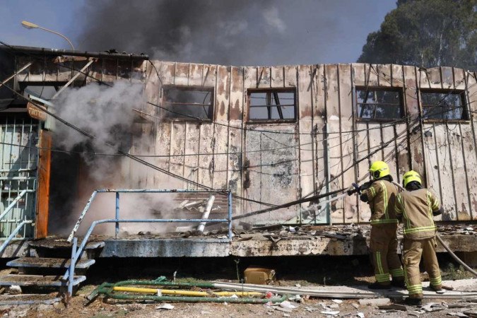 Bombeiros combatem incêndio em casa atingida por foguete do Hezbollah, em Kiryat Shmona. (norte de Israel)