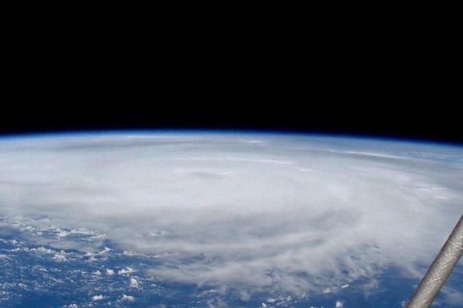 Um homem caminha na chuva com sacolas de mantimentos enquanto o furacão Helene se intensifica antes de sua esperada chegada em Big Bend, na Flórida, em Apalachicola, Flórida, EUA, 26 de setembro de 2024. -  (crédito: Reuters)