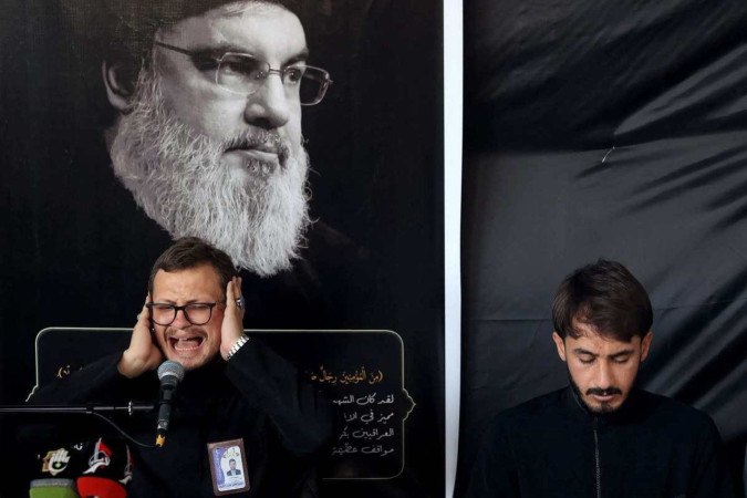 Homem iraquiano reza a Nasrallah na cidade sagrada xiita de Karbala 