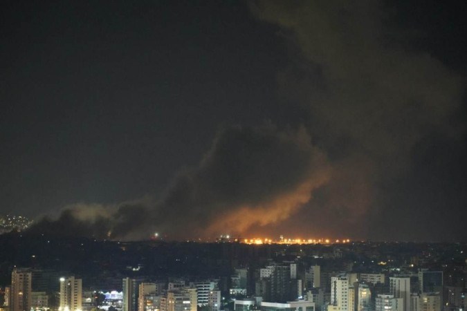 A fumaça sobe do local de um ataque aéreo israelense que teve como alvo um bairro no subúrbio ao sul de Beirute no início de 1º de outubro de 2024 (horário local). -  (crédito:  ETIENNE TORBEY / AFP)