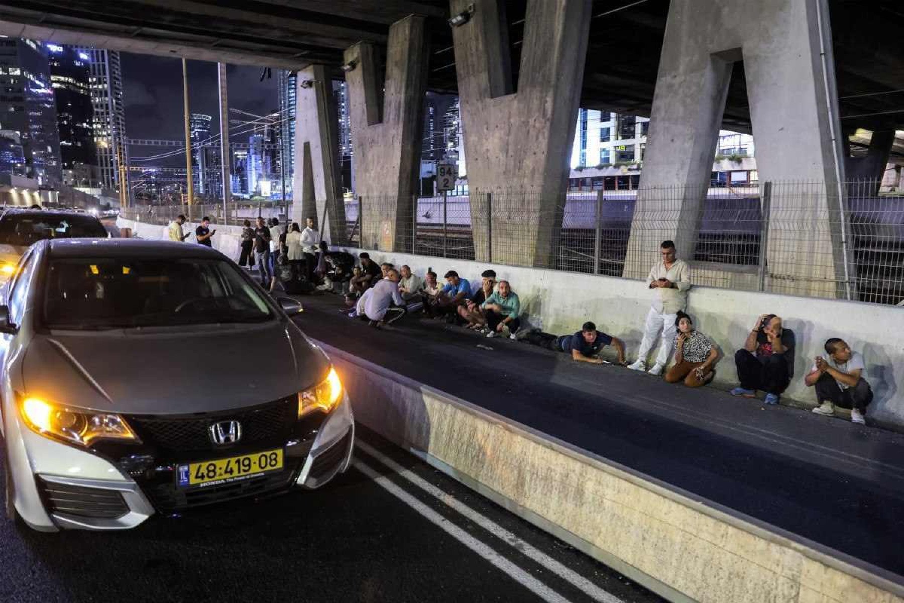 Israelenses se protegem sob ponte em rodovia perto de Tel Aviv