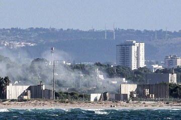 Uma nuvem de fumaça surge depois que mísseis foram disparados das baterias do sistema de defesa antimísseis Iron Dome de Israel para interceptar foguetes sobre a cidade de Acre, no norte -  (crédito: Ahmad GHARABLI / AFP)