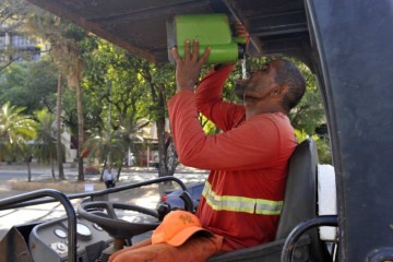 Ademar Moreira opera máquina de asfalto e mantém a garrafa grande cheia de água fresca -  (crédito: Fotos: Minervino Júnior/CB/D.A Press)