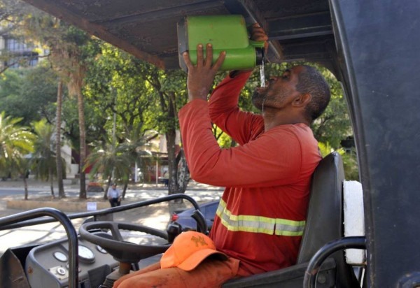 Ademar Moreira opera máquina de asfalto e mantém a garrafa grande cheia de água fresca -  (crédito: Fotos: Minervino Júnior/CB/D.A Press)